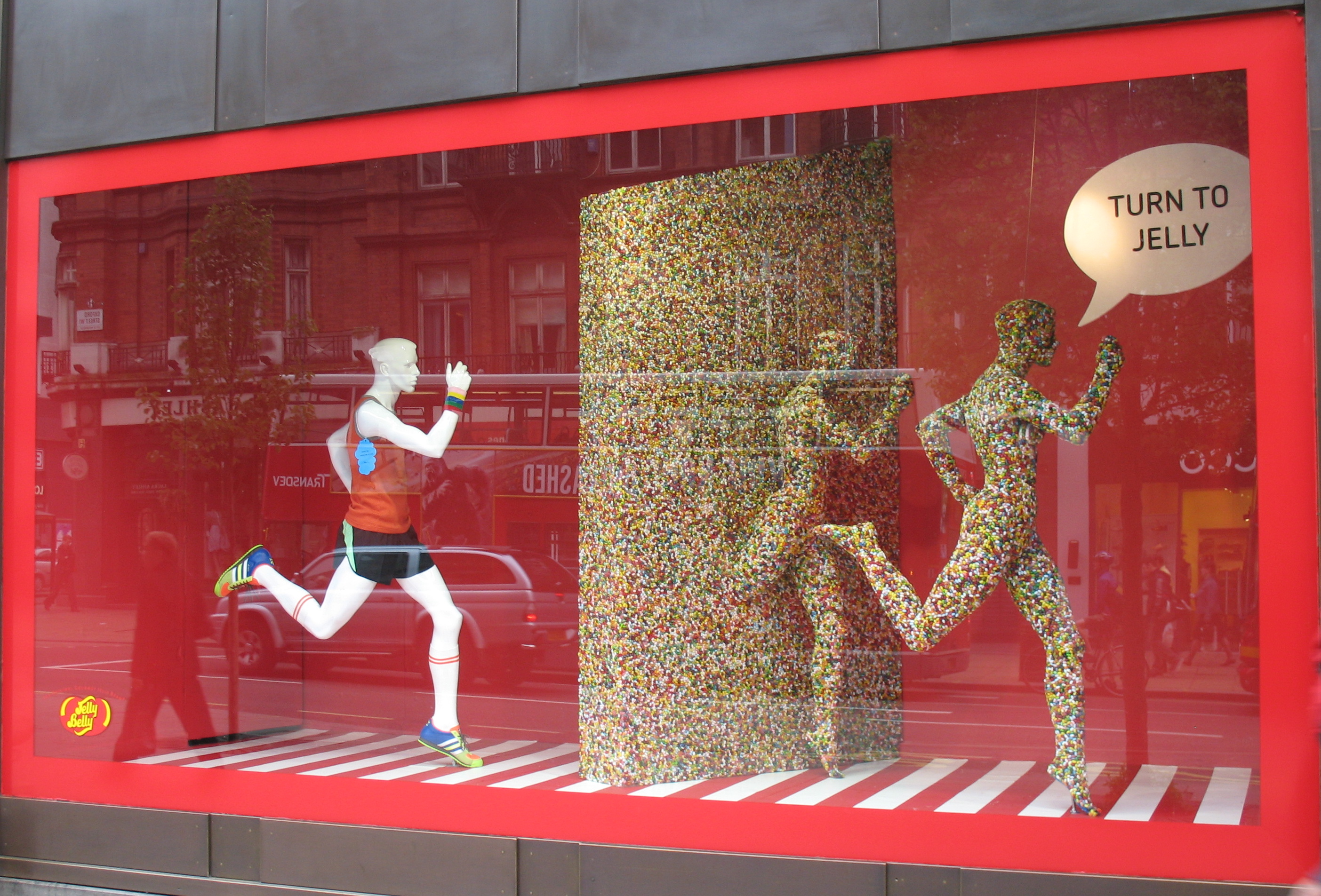 Window display of running mannequins with the caption 'Turn to jelly'