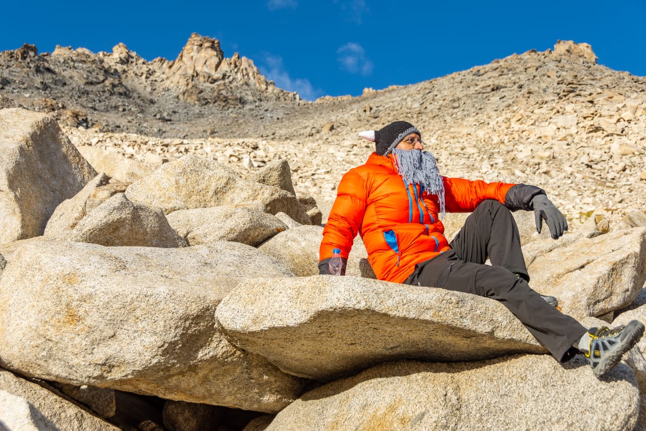 Runner resting on boulders high in the mountains